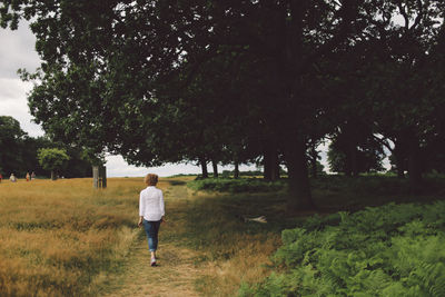 Rear view of young woman walking on footpath