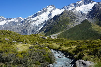 Scenic view of snowcapped mountains against clear blue sky