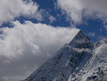 Low angle view of snowcapped mountains against sky