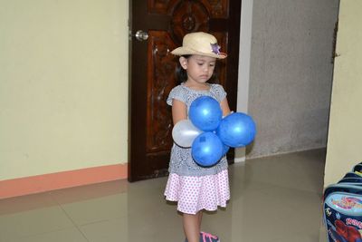 Full length of cute girl wearing hat standing on floor