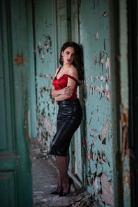 Portrait of woman standing at entrance of abandoned building