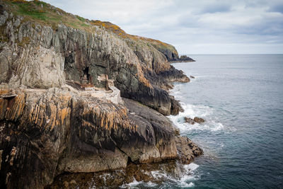 Rock formations by sea against sky