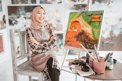 Portrait of young woman using mobile phone while sitting at home