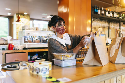 Midsection of woman holding ice cream on table