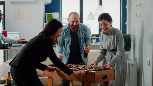 Cheerful colleagues playing foosball