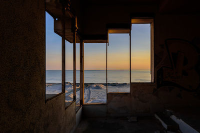Scenic view of sea seen through window during sunset