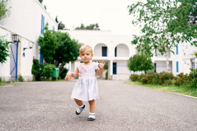 Full length of cute girl standing against building