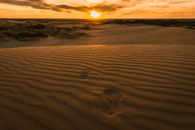 Scenic view of desert against sky during sunset