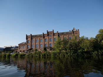 Building by lake against clear sky