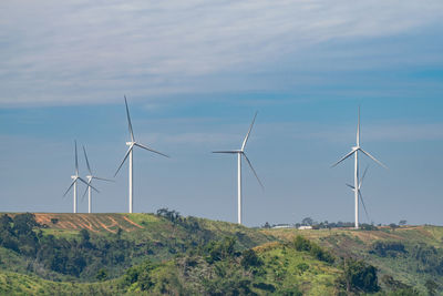 Wind turbines on land against sky