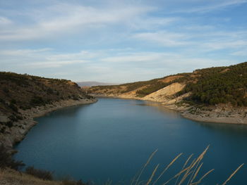 Scenic view of river amidst mountains against sky