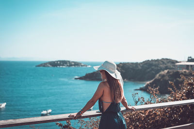 Young woman looking at sea against sky