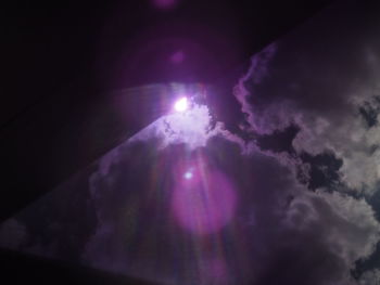 Low angle view of illuminated purple sky at night