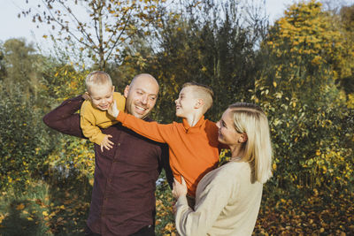 Smiling parents with children enjoying in autumn