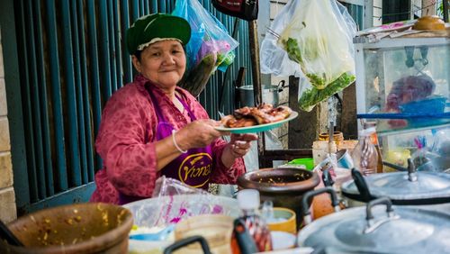 Woman eating food at market stall