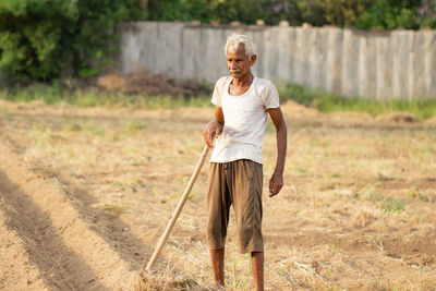 Close-up of an indian farmer works the field with a shovel