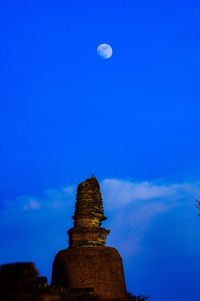 Low angle view of moon against blue sky