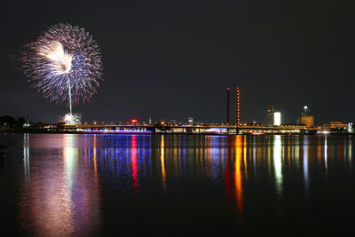 Firework display over river at night