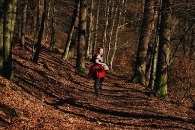 Side view of teenage girl wearing costume running in forest