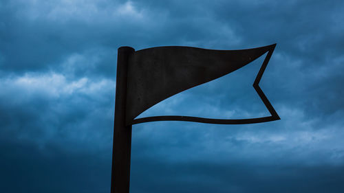 Low angle view of flag against cloudy sky