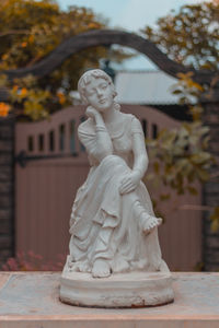Statue against trees and building
