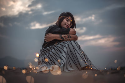 Portrait of young woman against sky during sunset