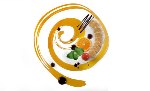 High angle view of fruit in plate against white background