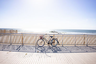 Bicycle on beach against clear sky