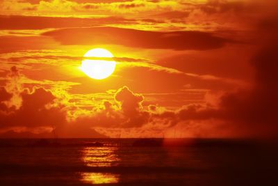 Scenic view of sea against cloudy sky at sunset