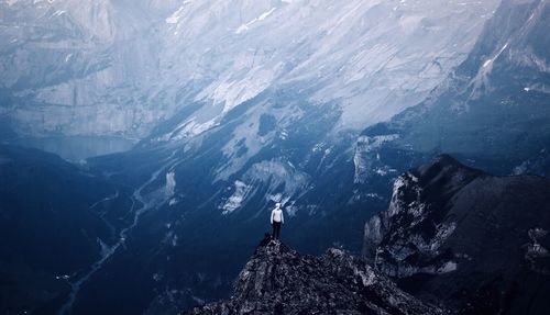 Low angle view of person standing on rocks against mountain