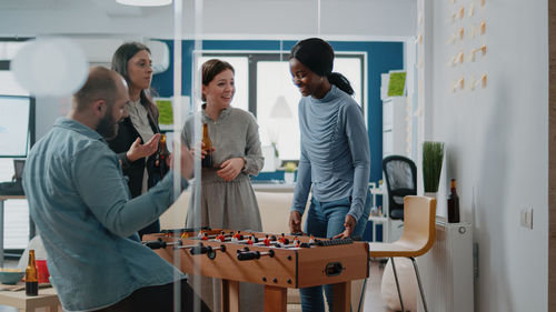 Business colleagues playing foosball at office