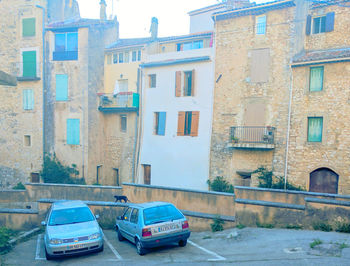 Cars on road by buildings in city