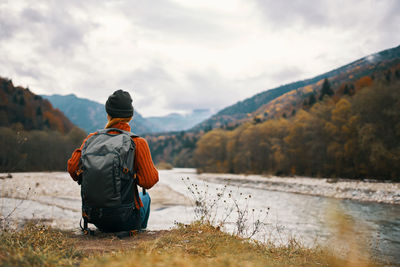 Rear view of man looking at mountain against sky