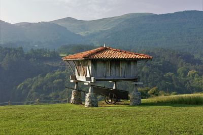 Built structure on field against mountain