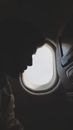 Close-up of man sitting in airplane window