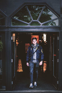 Portrait of young man standing against built structure