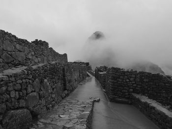 Footpath leading towards mountain against sky