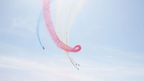 Low angle view of airplanes flying against sky