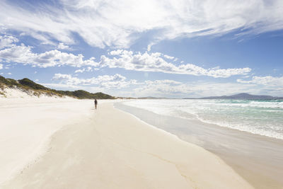 Full length of man walking on beach against sky