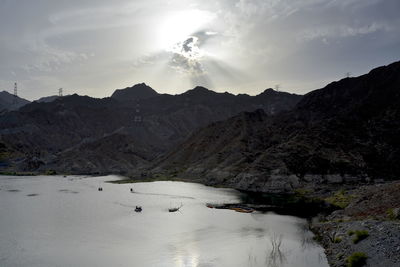 Scenic view of river by snowcapped mountains against sky