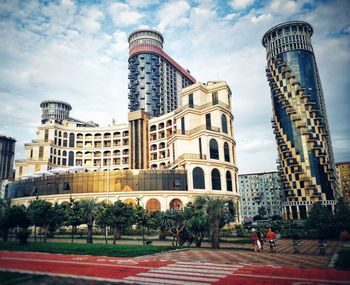 Buildings in city against cloudy sky