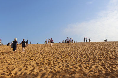 People at beach against sky