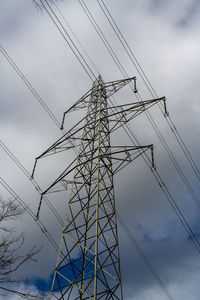 Low angle view of electricity pylon against sky