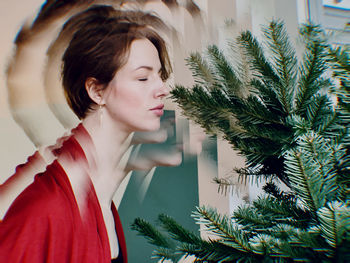 Woman looking away while standing against trees