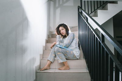 Portrait of young woman sitting on staircase