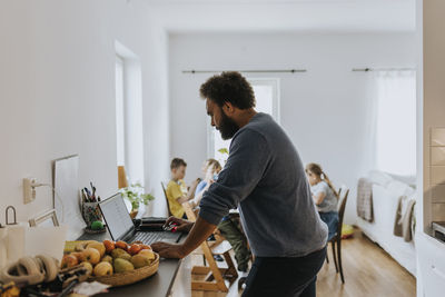 Man working from home and taking care of children