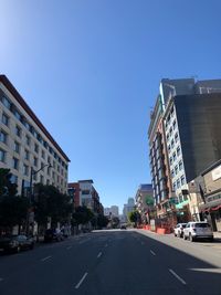 City street and buildings against clear blue sky