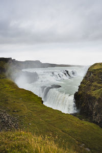 Scenic view of waterfall against sky