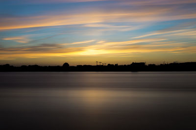 Scenic view of lake against orange sky