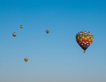 Low angle view of hot air balloons against blue sky